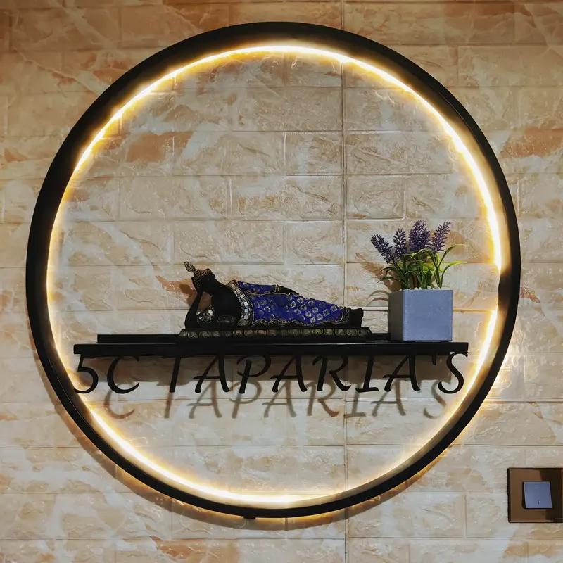 A backlit metal ring name plate on a stone wall